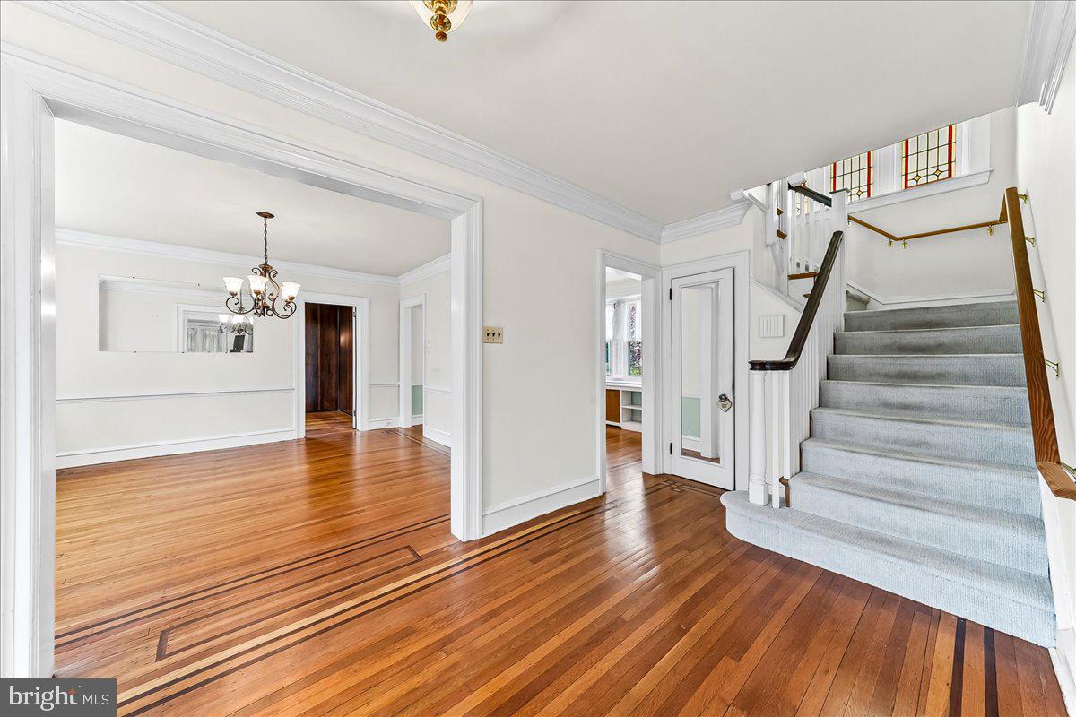 216 East Manoa Road Havertown, PA 19083 - Photo 6 of 37 a view of a room with wooden floor staircase and a kitchen