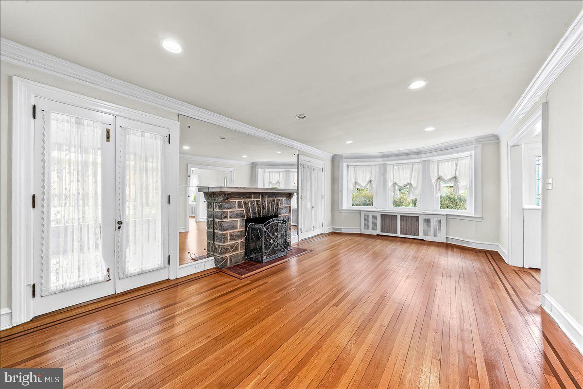 216 East Manoa Road Havertown, PA 19083 - Photo 7 of 37 a view of empty room with wooden floor and fireplace