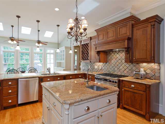 11300 Moonsprite Way Raleigh, NC 27614 - Photo 5 of 25 a kitchen with stainless steel appliances granite countertop a sink a stove and a wooden cabinets