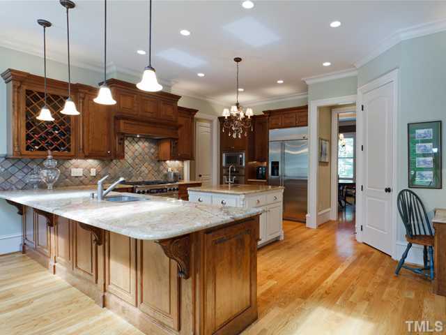 11300 Moonsprite Way Raleigh, NC 27614 - Photo 6 of 25 a kitchen with kitchen island a sink stove and wooden floor