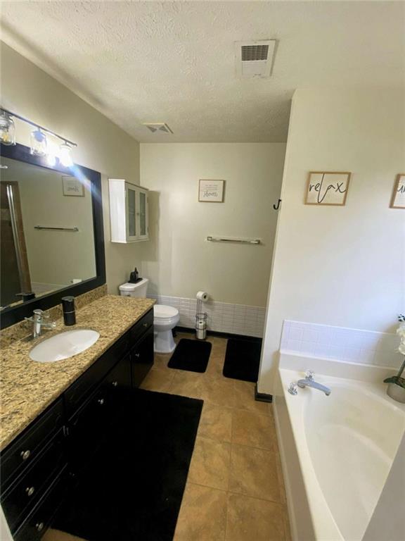 188 Waters Edge Drive Locust Grove, GA 30248 - Photo 12 of 25 a spacious bathroom with a granite countertop sink a toilet a mirror and bathtub