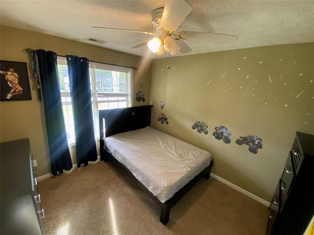 188 Waters Edge Drive Locust Grove, GA 30248 - Photo 14 of 25 a bedroom with a bed and a chandelier
