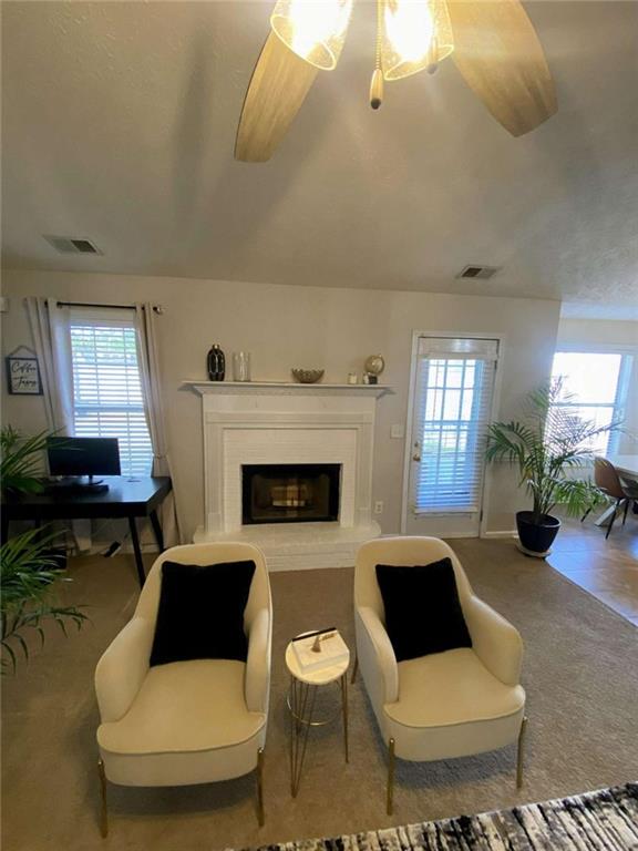 188 Waters Edge Drive Locust Grove, GA 30248 - Photo 8 of 25 a living room with furniture a fireplace and a chandelier