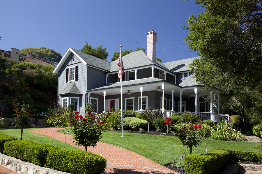 a front view of a house with a yard and potted plants