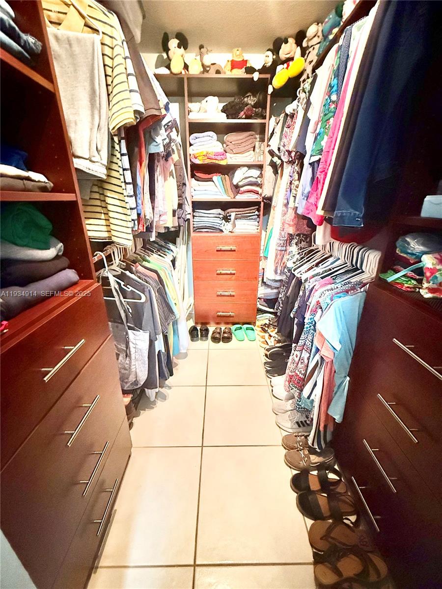 13267 Southwest 277th Terrace Homestead, FL 33032 - Photo 11 of 23 a view of walk in closet with clothes and shoes