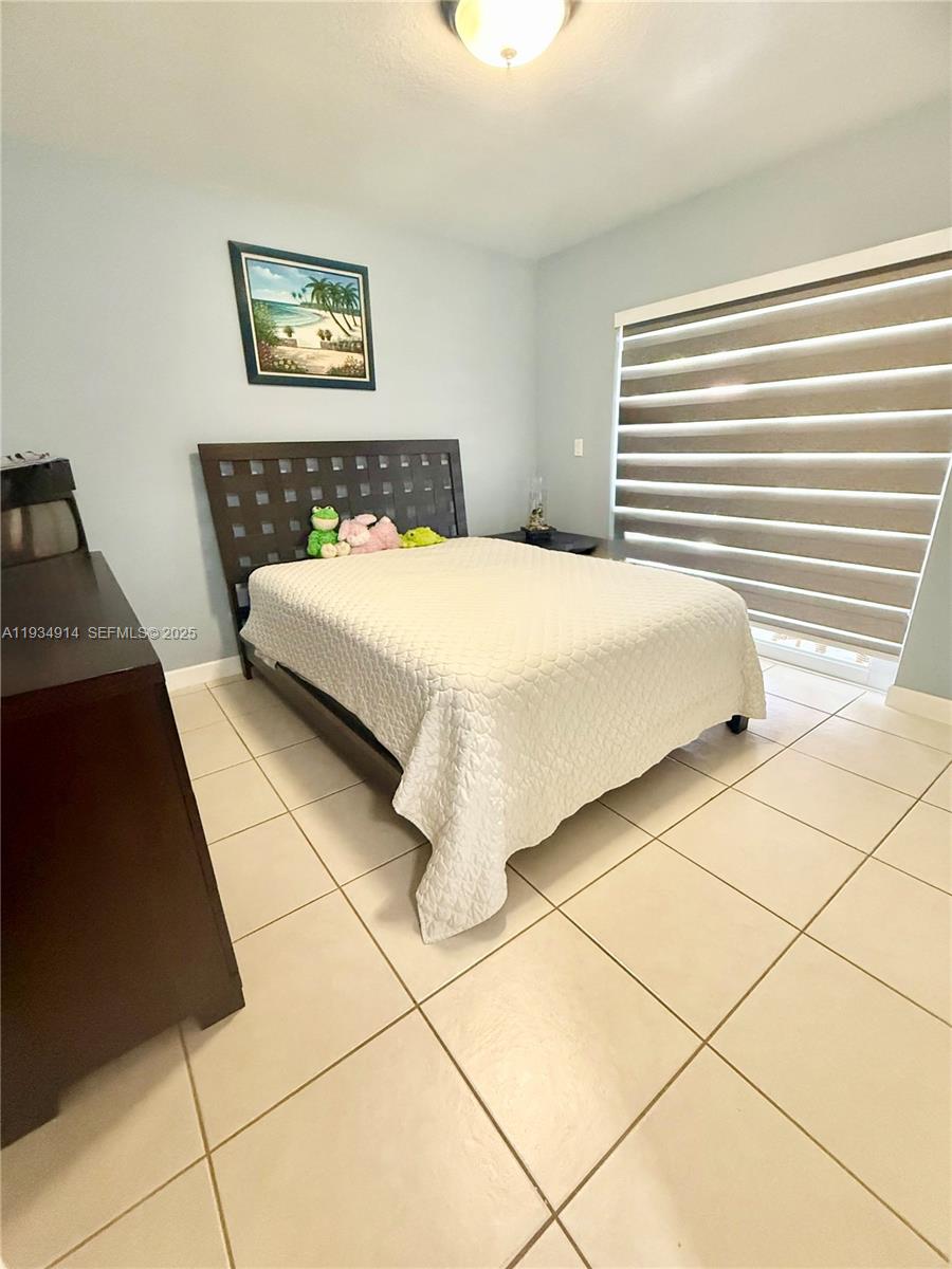 13267 Southwest 277th Terrace Homestead, FL 33032 - Photo 13 of 23 a bedroom with a bed and a wall painting