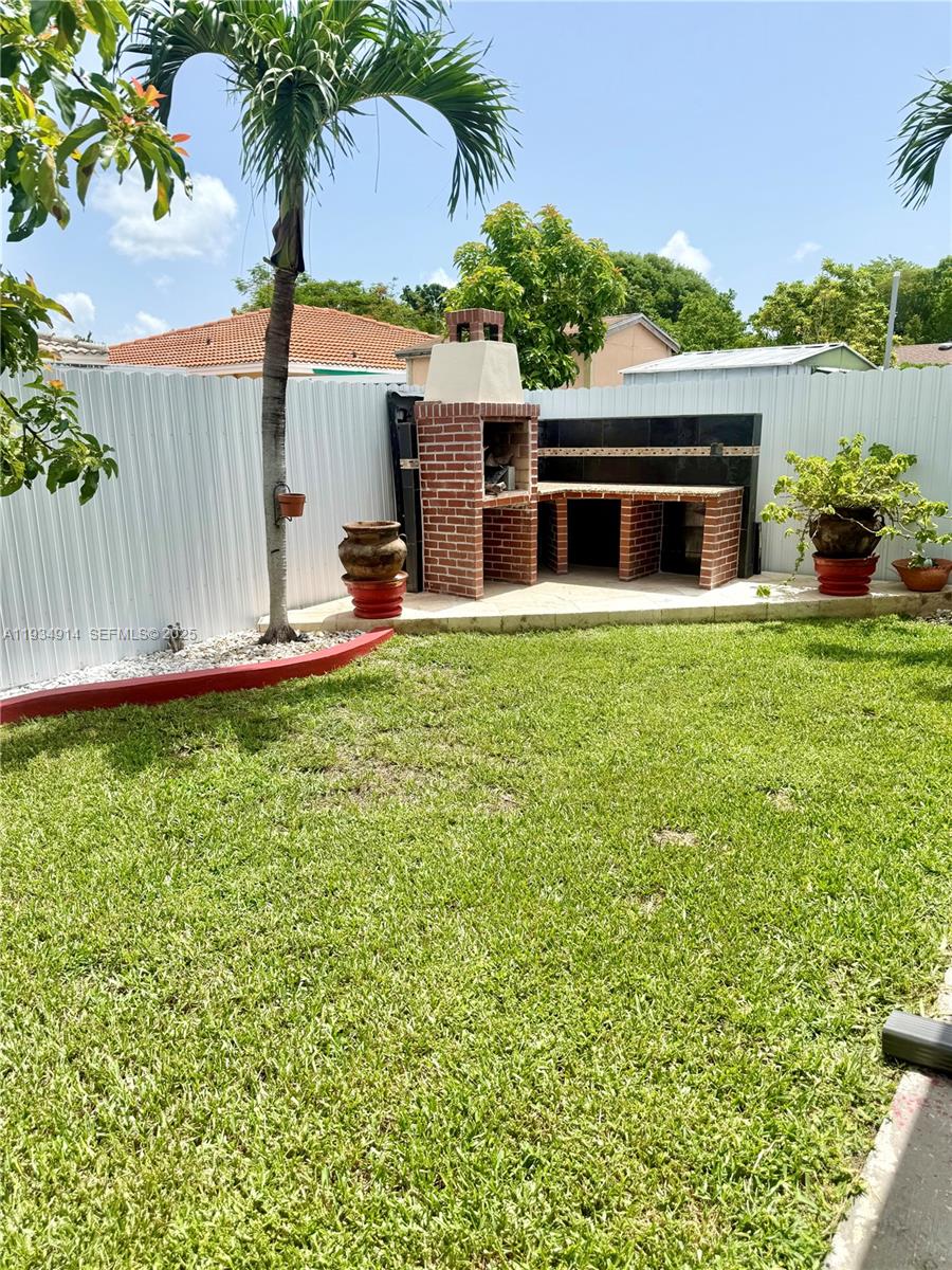 13267 Southwest 277th Terrace Homestead, FL 33032 - Photo 19 of 23 a front view of a house with a garden and yard