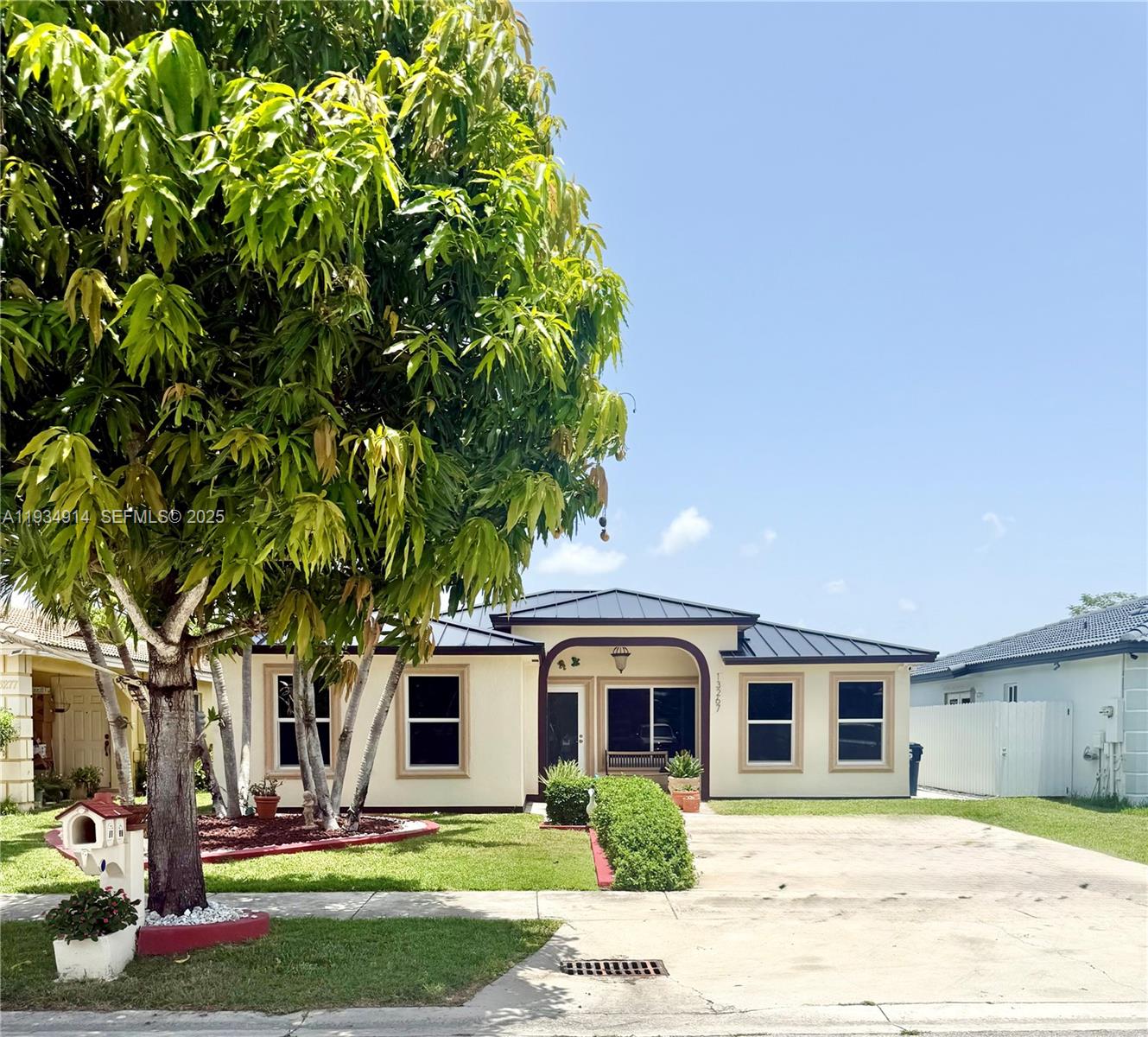 13267 Southwest 277th Terrace Homestead, FL 33032 - Photo 3 of 23 a front view of a house with a garden