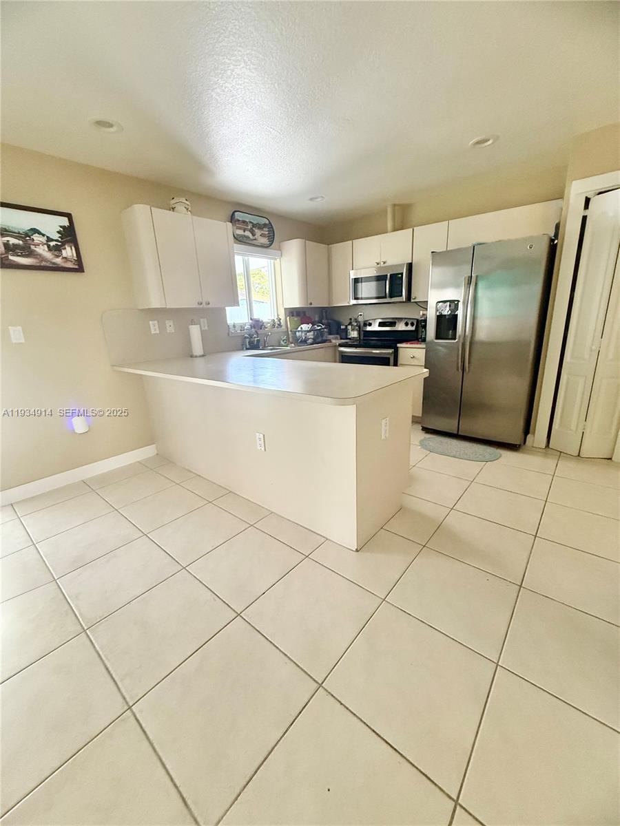 13267 Southwest 277th Terrace Homestead, FL 33032 - Photo 6 of 23 a kitchen with stainless steel appliances a refrigerator sink and microwave