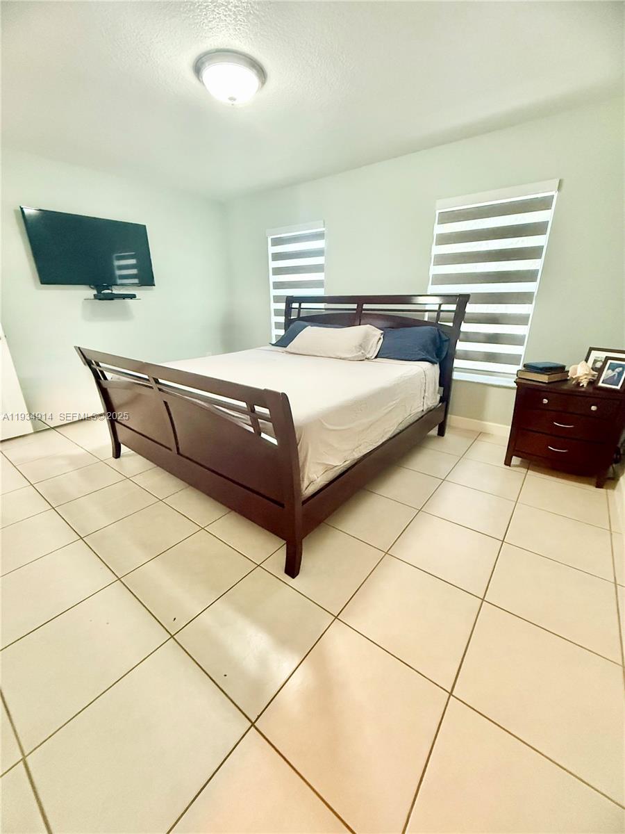 13267 Southwest 277th Terrace Homestead, FL 33032 - Photo 9 of 23 a bedroom with a bed and a couch