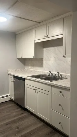 a kitchen with granite countertop white cabinets and a sink