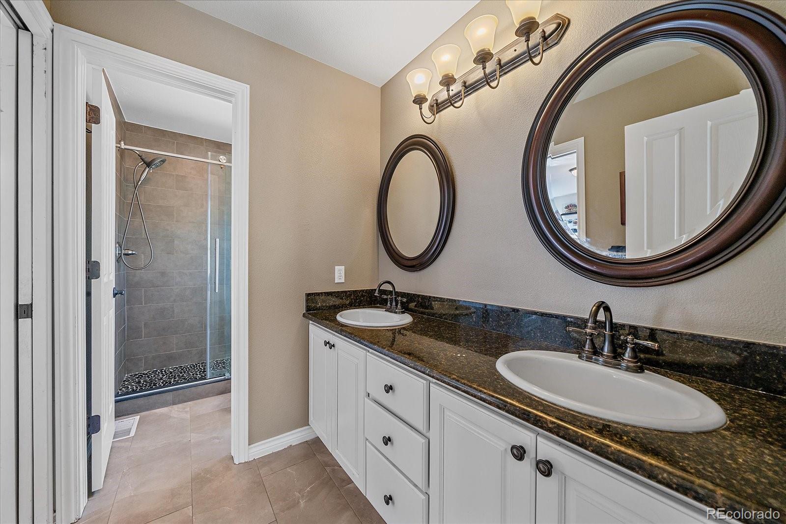 73 North Ranch Road Littleton, CO 80127 - Photo 27 of 49 a bathroom with a granite countertop double vanity sink and a mirror