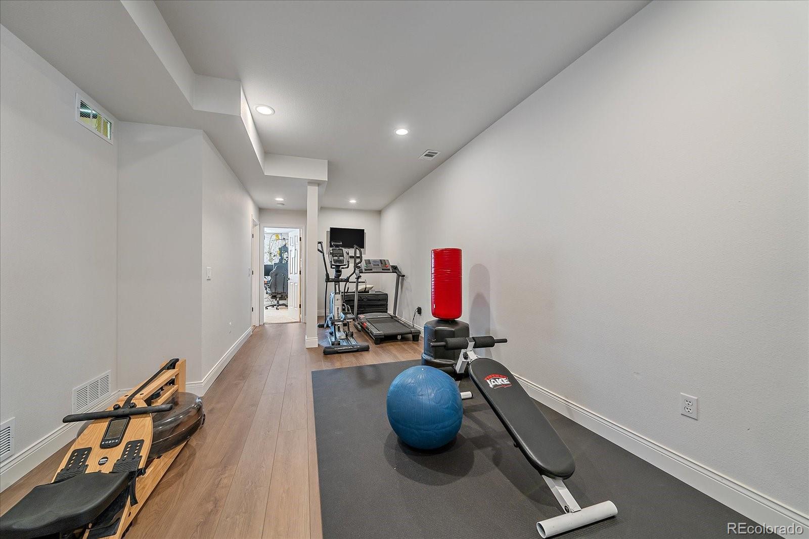 73 North Ranch Road Littleton, CO 80127 - Photo 32 of 49 a room with gym equipment and wooden floor