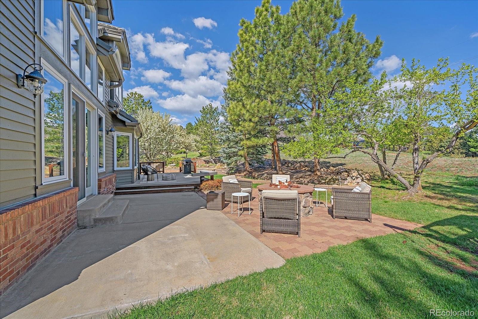 73 North Ranch Road Littleton, CO 80127 - Photo 36 of 49 a view of a patio with couches and table and chairs next to yard with wooden fence