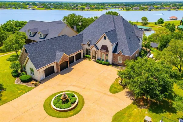 an aerial view of a house with swimming pool and large trees