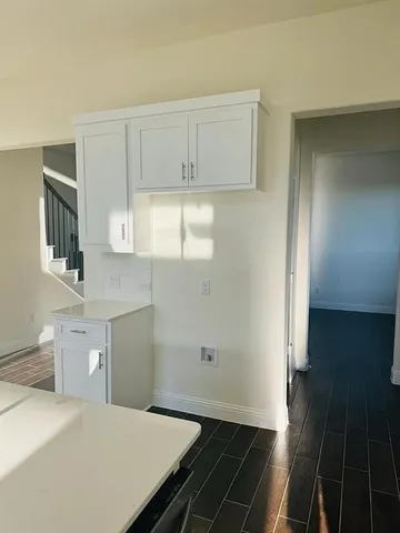a open kitchen with white cabinets and wooden floor