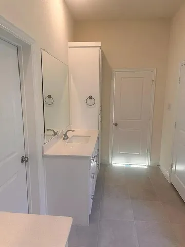a bathroom with a sink and mirror with shower