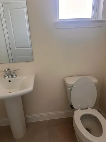 a bathroom with a sink a toilet and a mirror