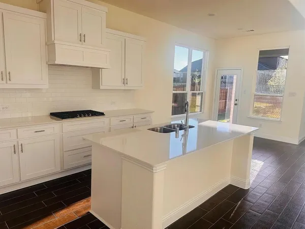 a kitchen with cabinets appliances a sink and a counter top space