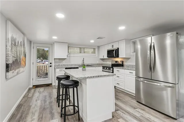 a kitchen with stainless steel appliances granite countertop a refrigerator stove microwave and sink