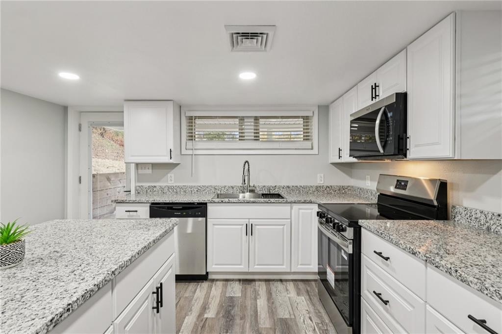 305 Queenstown Road Karns City, PA 16041 - Photo 16 of 38 a kitchen with stainless steel appliances granite countertop a sink stove microwave and cabinets