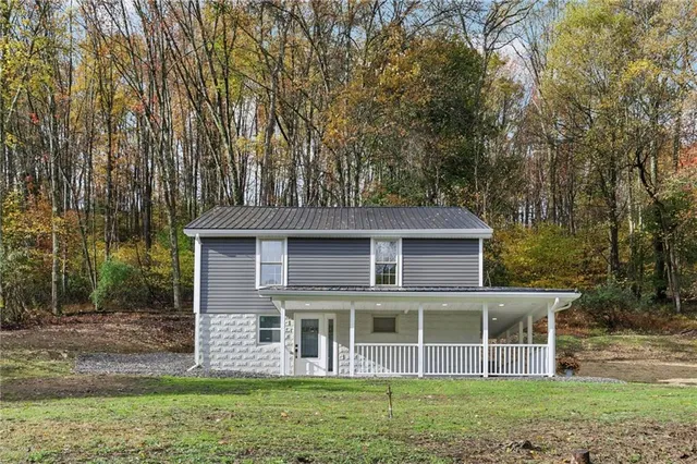 a view of a house with yard and sitting area