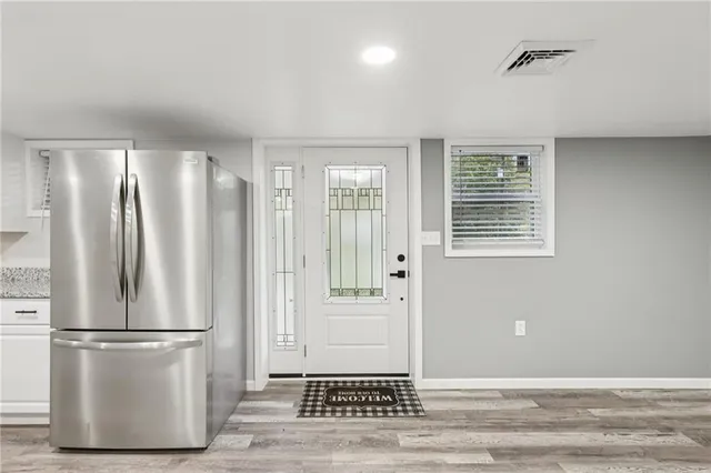 a view of a kitchen with refrigerator and wooden floor