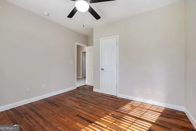 a view of a room with wooden floor and chandelier fan