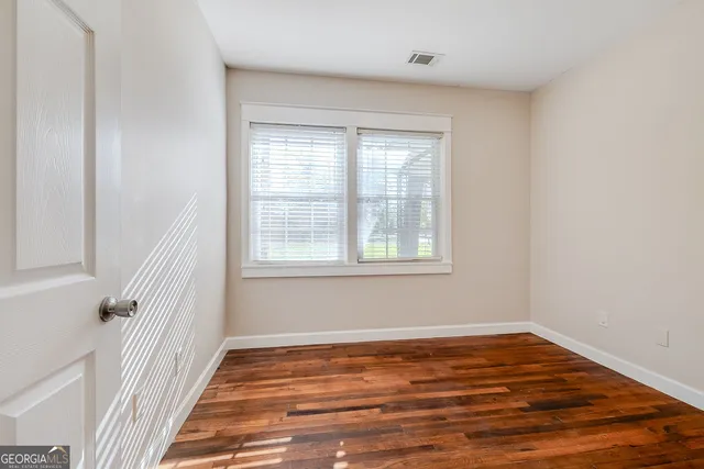 a view of a room with wooden floor and window