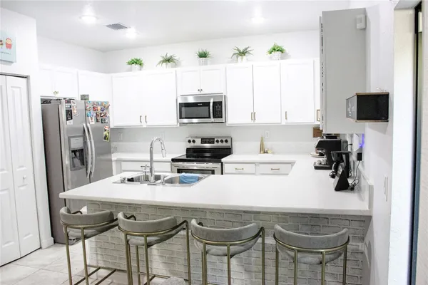 a kitchen with a sink a stove a microwave and cabinets