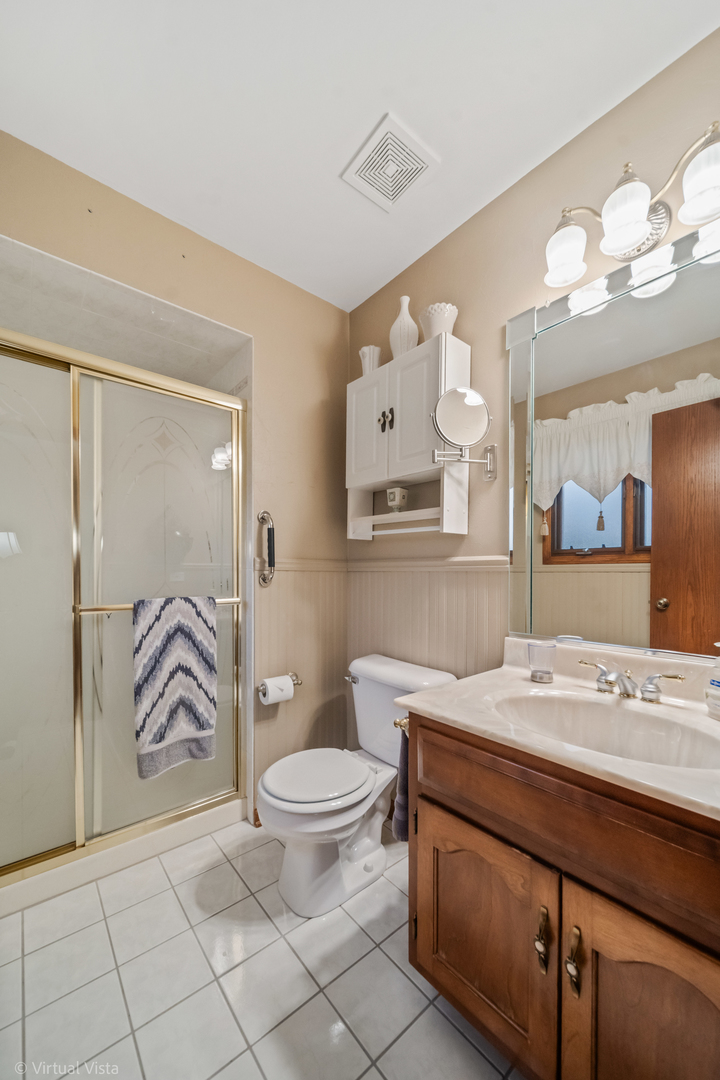 1262 Rutgers Drive Woodridge, IL 60517 - Photo 14 of 22 a bathroom with a sink a toilet and a mirror