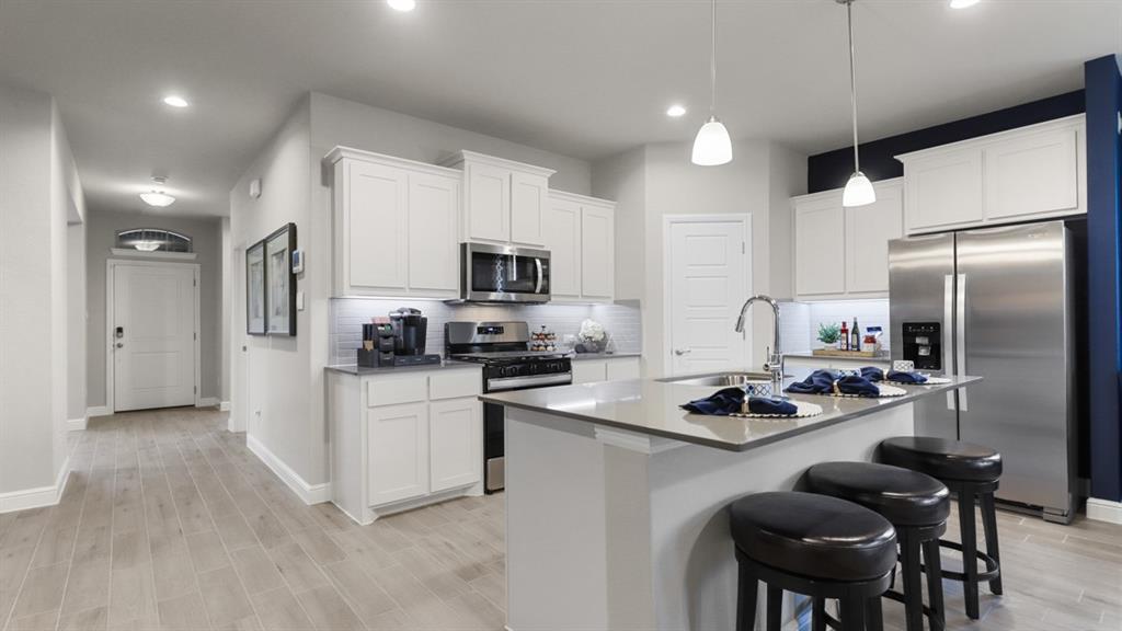 240 Windmill Drive Rhome, TX 76078 - Photo 33 of 35 a kitchen with refrigerator a stove a sink and chairs