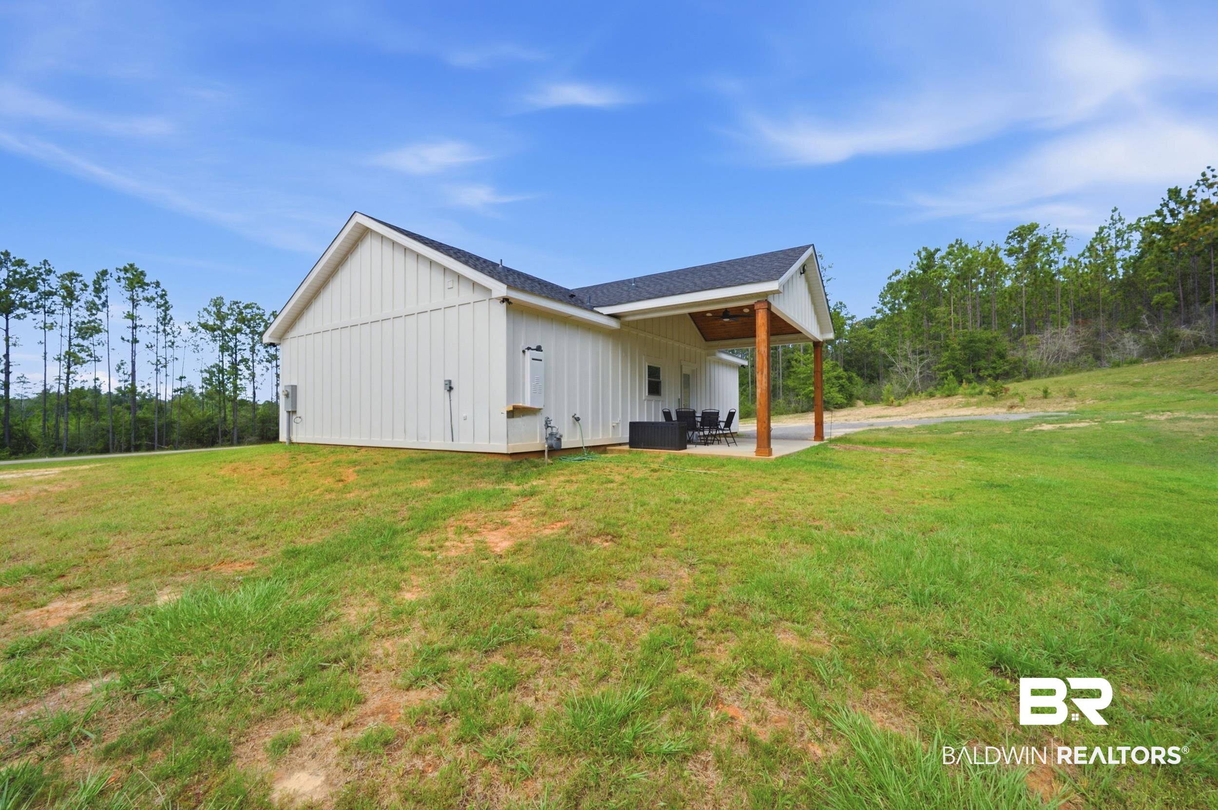 12019 Red Hill Rd Extension Bay Minette, AL 36507 - Photo 9 of 48 White board and batten exterior with a dark shingle roof and an exterior air conditioning unit