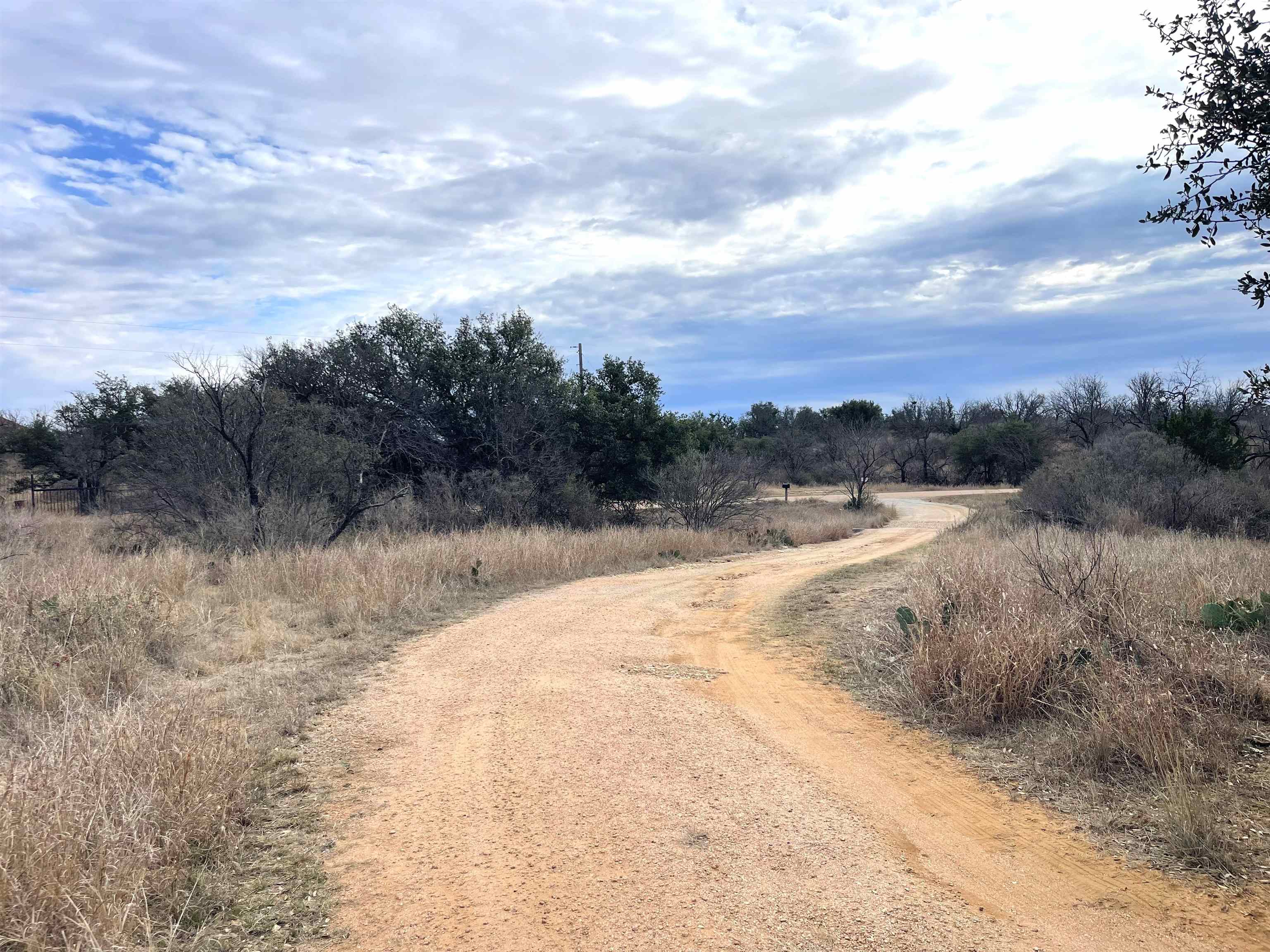323 Thurman Loop Llano, TX 78643 - Photo 1 of 18 a view of a dry yard with wooden fence
