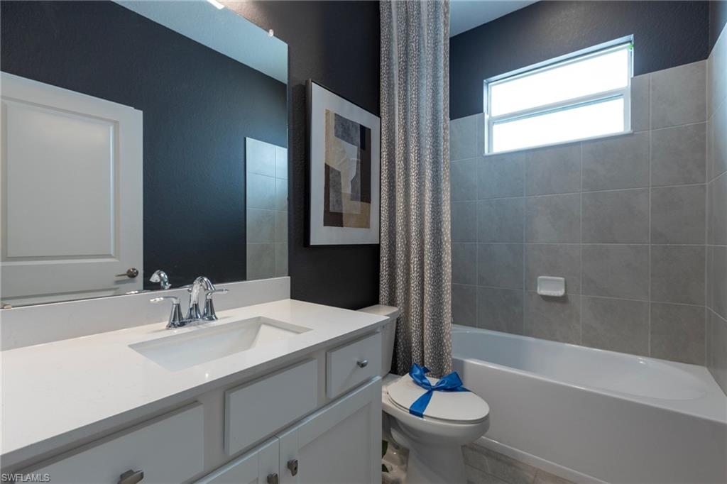 14920 Jadestone Drive Babcock Ranch, FL 33982 - Photo 21 of 25 a bathroom with a sink a toilet a mirror and shower