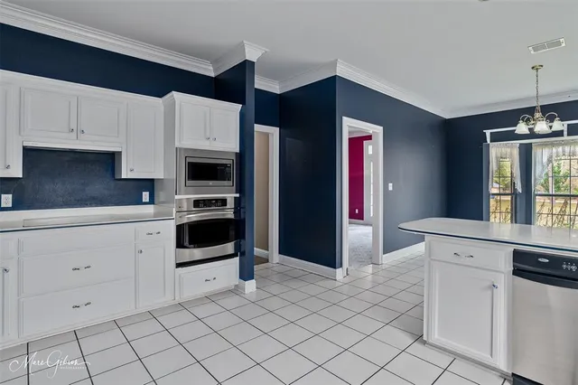 a kitchen with white cabinets and appliances