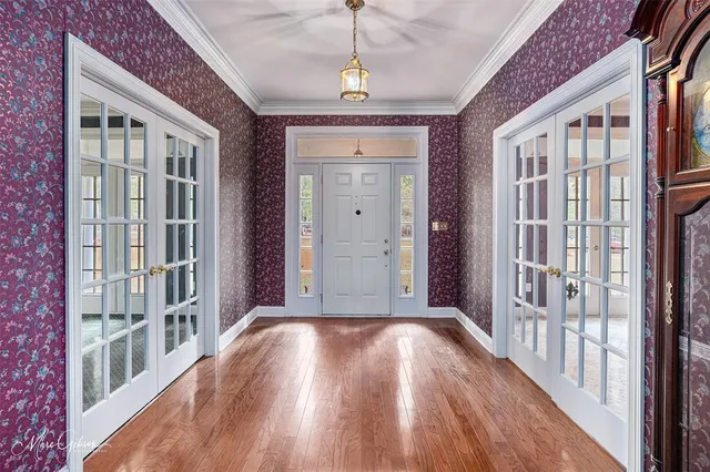 a view of a hallway with wooden floor and windows