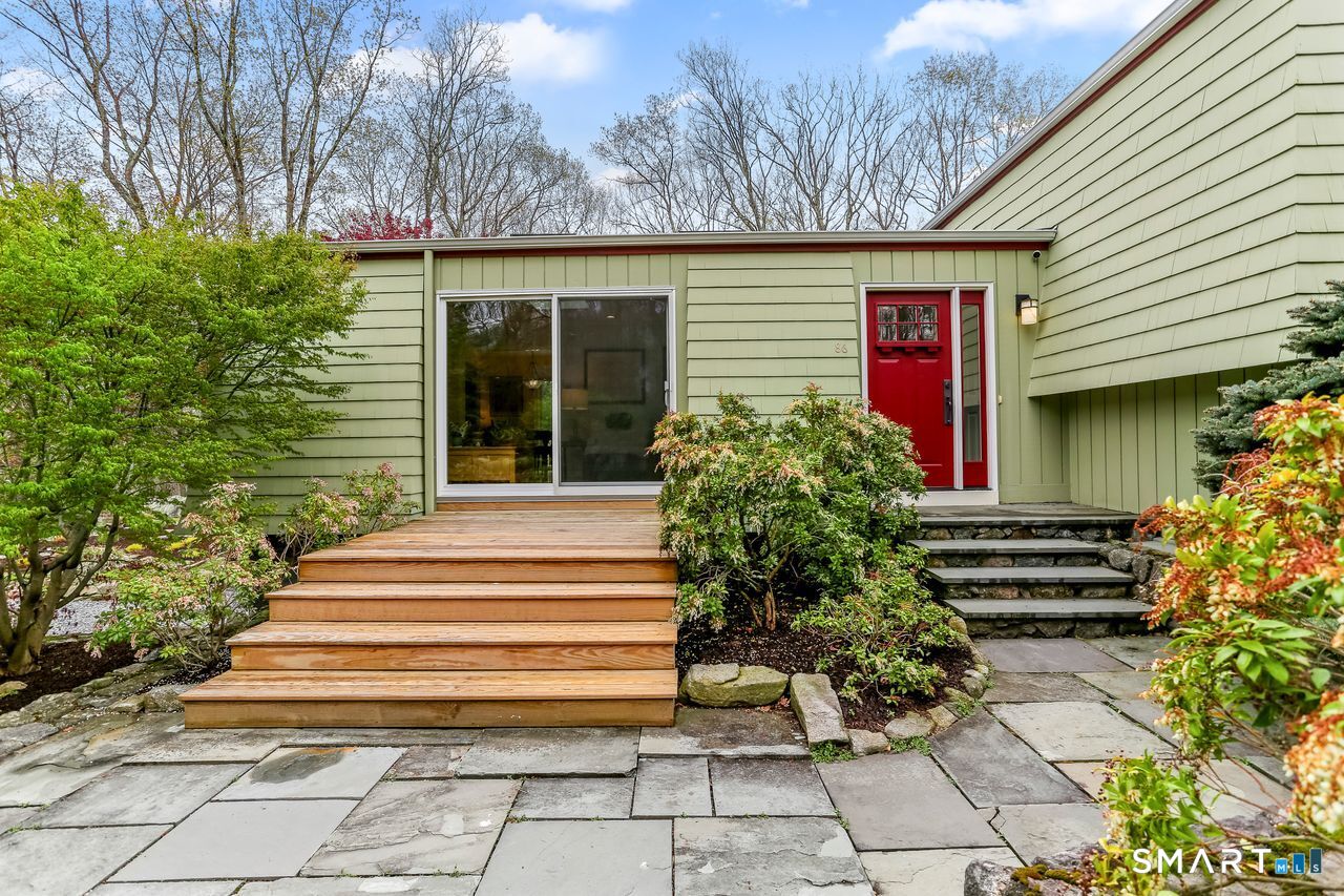 86 Seventy Acre Road Redding, CT 06896 - Photo 32 of 40 a front view of a house with plants and outdoor seating