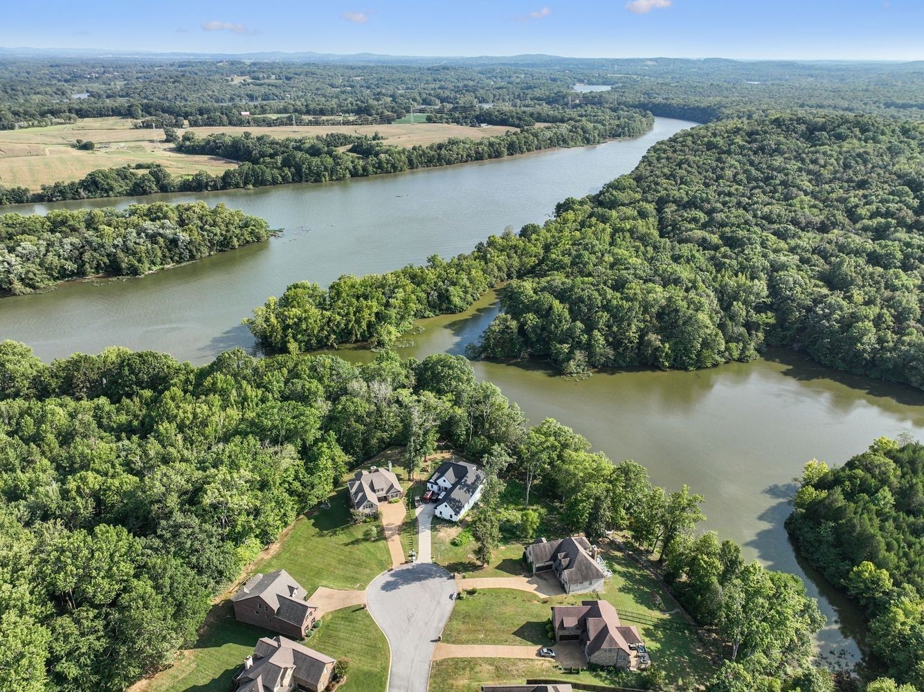 an aerial view of a residential houses with outdoor space and lake view