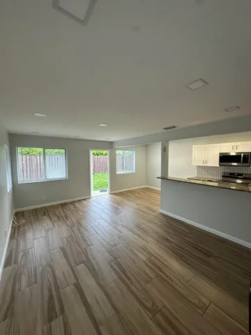 an empty room with wooden floor and a window