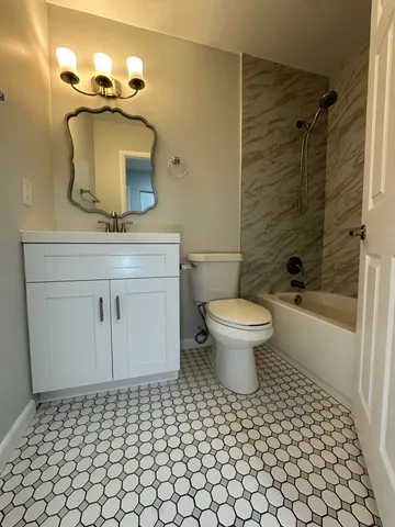 a bathroom with a toilet sink and mirror