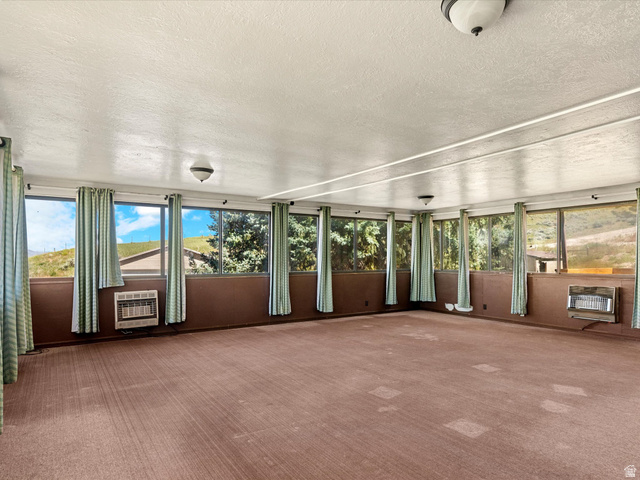15680 North Beaver Dam Road Collinston, UT 84306 - Photo 19 of 49 Sunroom with expansive window walls, two wall-mounted heaters, and overhead lighting fixtures