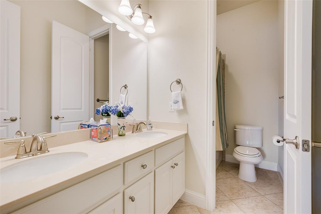 14026 Gutierrez Road Frisco, TX 75035 - Photo 22 of 36 a bathroom with a sink a toilet and a large mirror