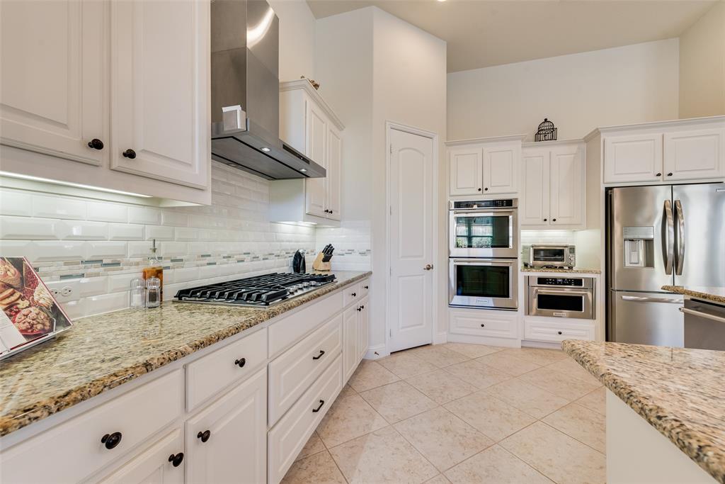 14026 Gutierrez Road Frisco, TX 75035 - Photo 4 of 36 a kitchen with granite countertop a sink stainless steel appliances and white cabinets