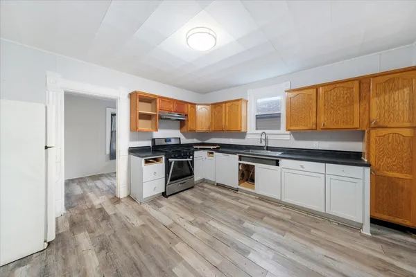 a kitchen with stainless steel appliances granite countertop a stove a sink and a refrigerator