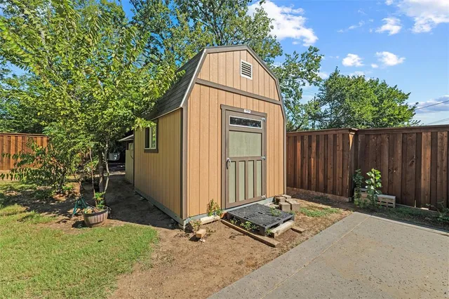 a view of backyard with potted plants and a large tree