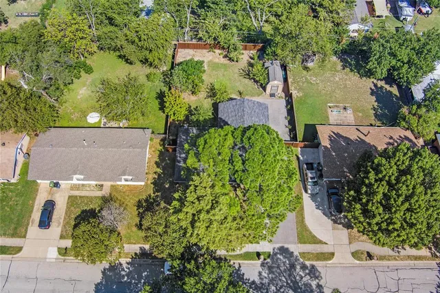 an aerial view of a house with a yard and trees