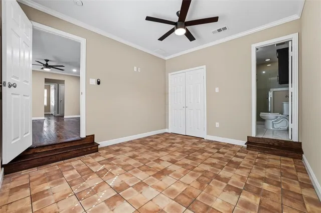 a view of a hallway to a room with wooden floor and a ceiling fan