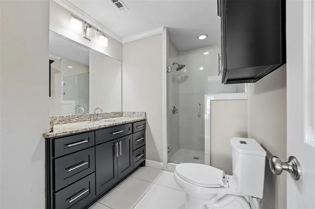 a bathroom with a granite countertop toilet sink and mirror
