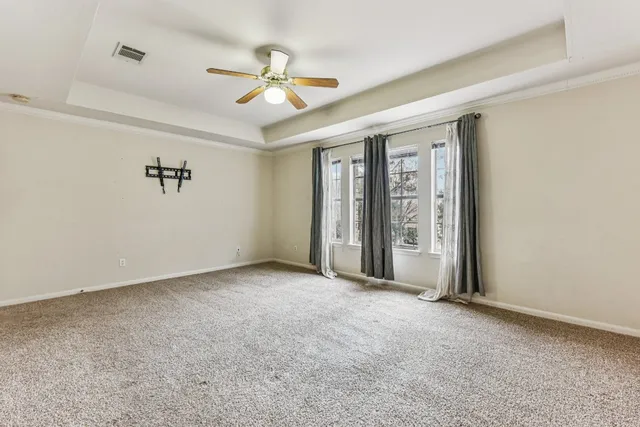 an empty room with a ceiling fan and a window